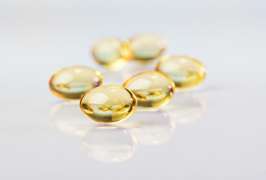 Pills (capsules) of cod-liver oil, macro view on white