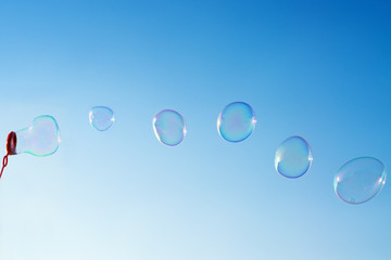 Natural shaped soap bubbles over blue sky