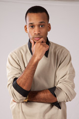 Handsome black man standing, hand on chin thinking