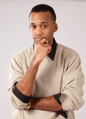 Handsome black man standing, hand on chin thinking