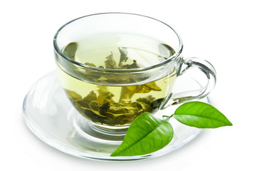 Tasse avec du thé vert et des feuilles vertes.