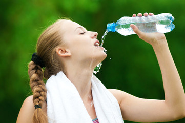 Woman drinking water after exercise