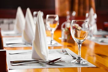 Behangcirkel Glasses and plates on table in restaurant © Nikolai Sorokin