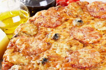 Italian cuisine. Pizza with salami, pickles and olives
