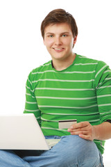 A young man sitting on the floor with a laptop