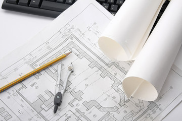 Compasses, a pencil  and a ruler over a draft