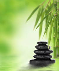 Tranquil zen design with stacked massage stones and bamboo - obrazy, fototapety, plakaty