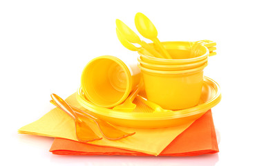 Bright yellow plastic tableware and napkins isolated on white