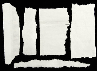 Torn white paper on black