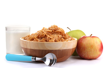 tasty cornflakes in wooden bowl, apples and glass of milk