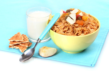 tasty cornflakes in bowl with dried fruits and glass of milk