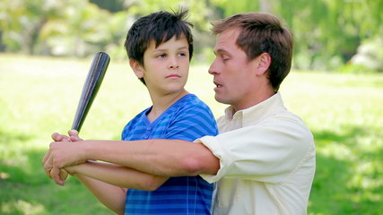 Smiling son playing baseball with his father - Powered by Adobe