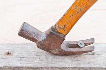 old rusted hammer pulling out a nail out of a piece