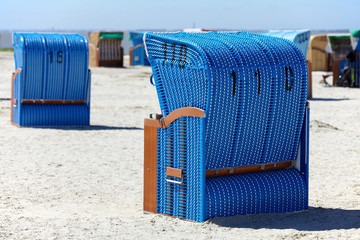 Fototapeta na wymiar Zwei blaue Strandkörbe von hinten am Strand der Ostsee