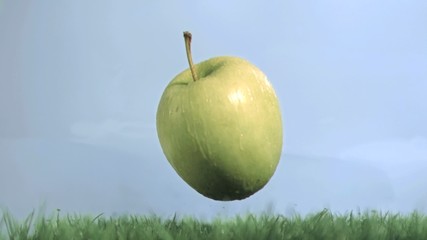 Green apple in super slow motion falling on the grass - Powered by Adobe