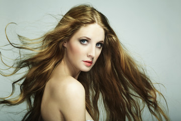 Fototapeta premium Portrait of young beautiful woman with long flowing hair