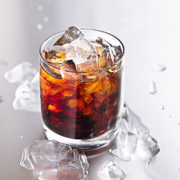 glass of cola with ice and water droplets