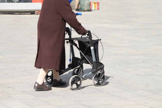 Alte Frau mit Rollator in der Fussgängerzone