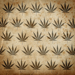 Grungy paper background with cannabis leaves