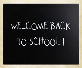 "Welcome back to school" handwritten with white chalk on a black