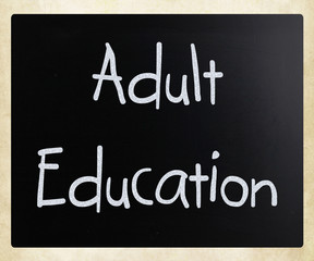 "Adult Education" handwritten with white chalk on a blackboard