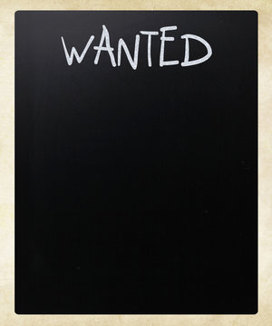 "Wanted" handwritten with white chalk on a blackboard