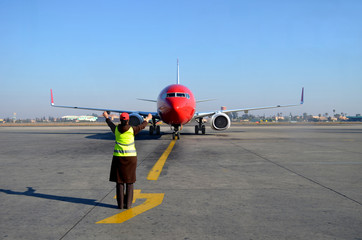 Woman signaling plane at airport
