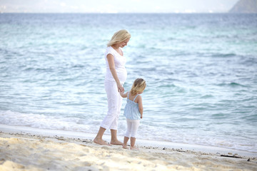 junge schwangere mutter mit ihrer tochter am strand