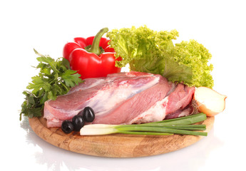 Raw meat and vegetables on a wooden board isolated on whitе