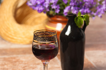 Black jug for wine and a glass of red wine
