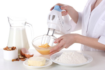 Female hands mixing eggs in bowl isolated on white