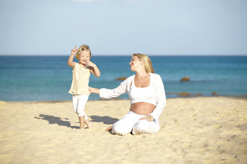 junge schwangere mutter mit ihrer tochter am strand