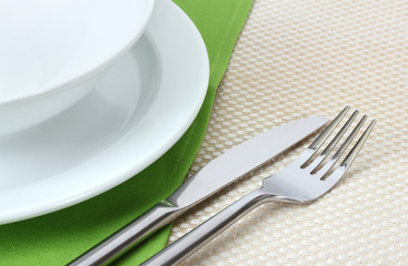 Table setting with fork, knife, plates, and napkin