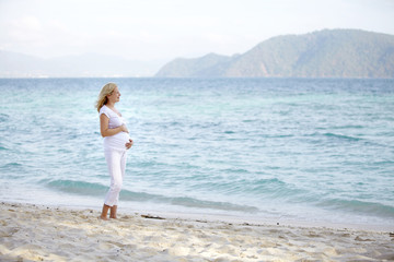schwangere junge frau am strand