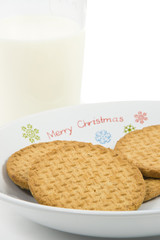 Crumbly cookies on dish with glass of milk