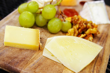 gourmet cheese plate with fruit and walnuts