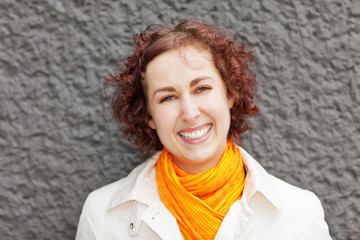 Lachende Frau an Mauer