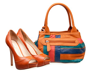 Pair of women shoes and handbag over white