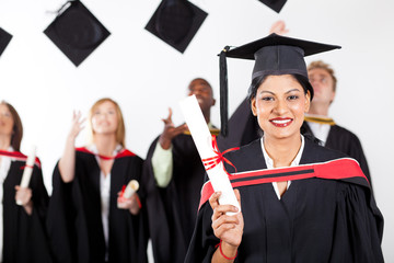 happy female indian graduate at graduation with classmates