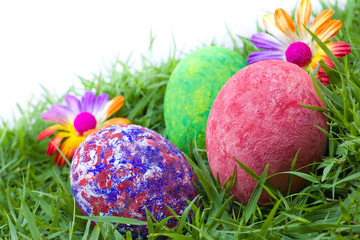 colorful painted three easter eggs on the grass with flowers