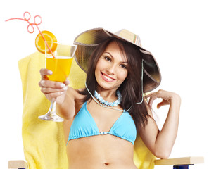 Girl in bikini drinking orange juice.