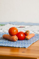 tomatoes and carrots on blue tablecloth