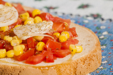 bruschetta with tomato, onion and corn on blue tablecloth