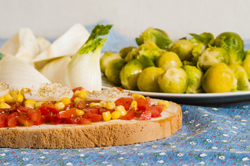 bruschetta with tomato, onion and corn on blue tablecloth