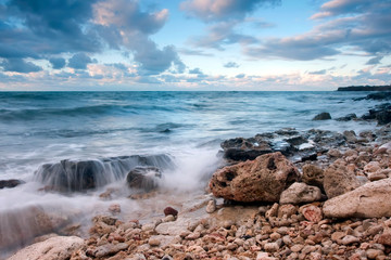 Beautiful rocky sea beach at the sunset