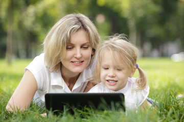 Little girl and mother with laptop outdoor