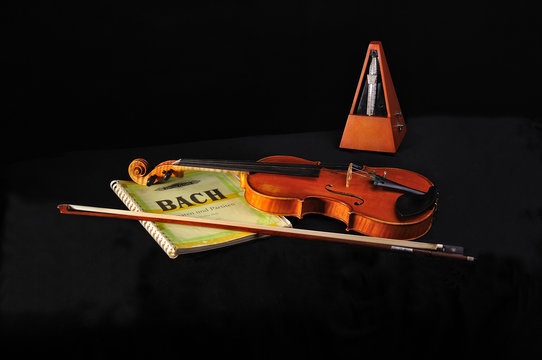 Violin, Bach score and metronome on black