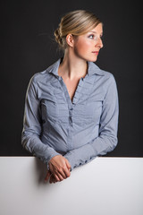 Woman behind white banner on dark gray background