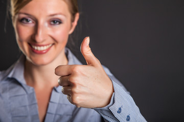 Businesswoman thumbs up on gray background