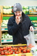 man choosing vegetables in supermarket store